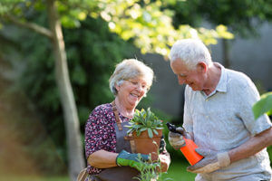 happy couple gardening after learning about the different Discovery Village Community Locations