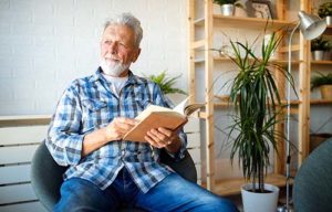 Man reads book at Discovery Village Senior Independent Living.